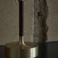 Braided burgundy leather handle on a sleek brass base, adding elegance to any decor.