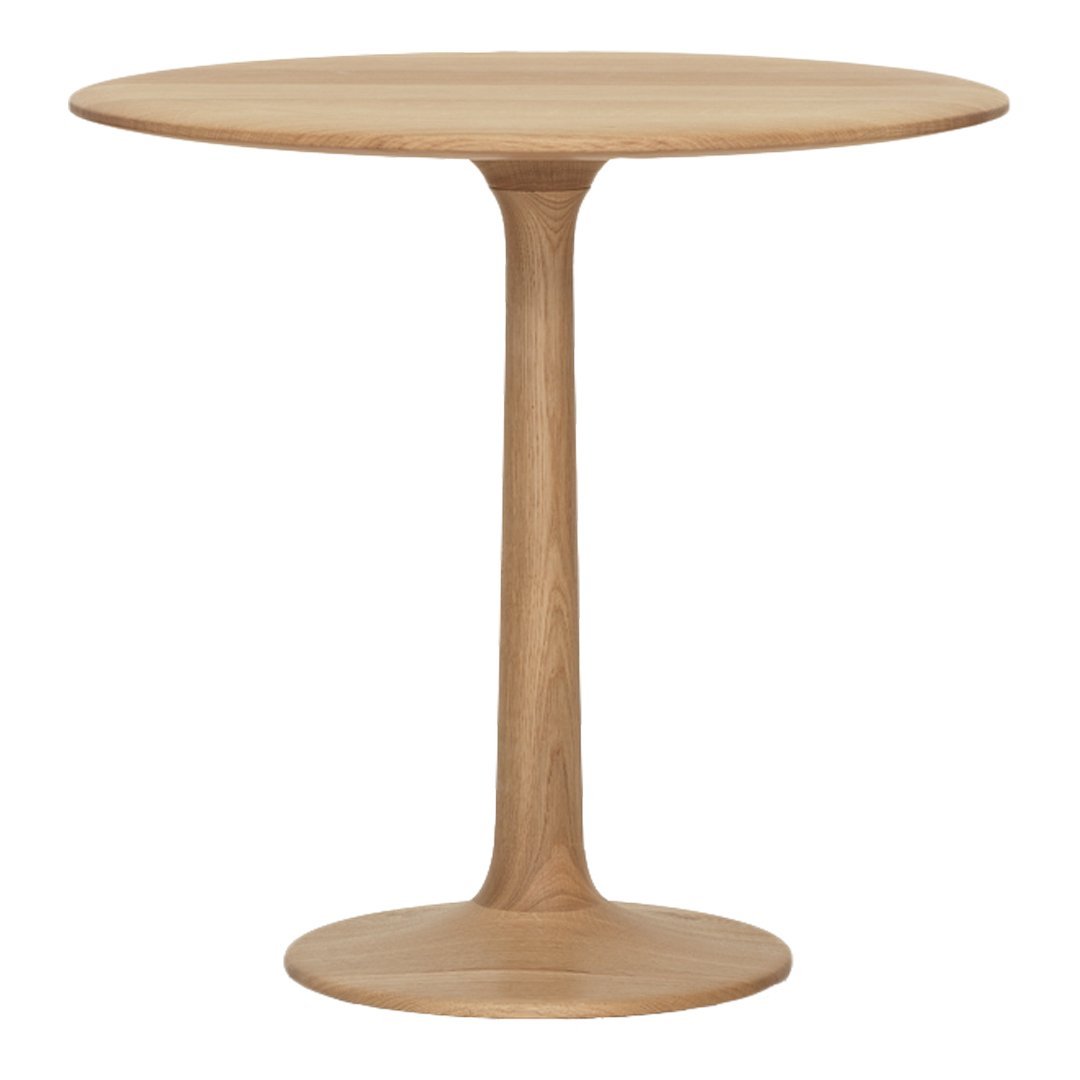 Round wooden table in light oak finish with a smooth, minimalist design and a single pedestal base.