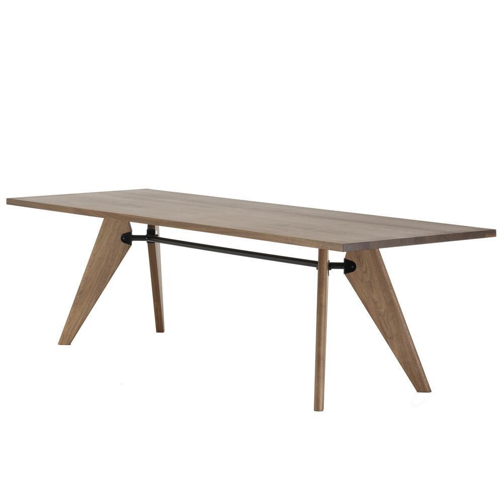 Modern wooden table with a warm oak finish and unique angled legs, featuring a sleek black metal support bar.