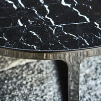 Black marble table top with striking white veining and a textured silver base. Elegant and modern design.
