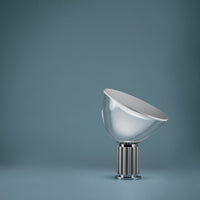 Modern metallic lamp with a sleek silver finish, set against a soft blue background. Elegant and contemporary design.
