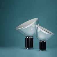Two modern glass lamps with white shades and black bases against a soft teal background.