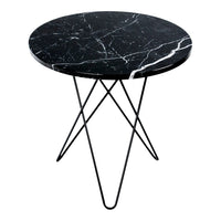 Round black marble table with white veining and sleek black metal legs, perfect for modern decor.