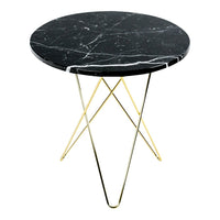 Round black marble table with white veins and golden metal tripod legs, modern and stylish design.