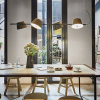 Stylish hanging lamps with beige shades, a neutral table setting, and natural wood accents in a bright, modern interior.