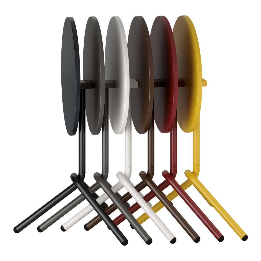 Set of six round tables in black, white, gray, brown, yellow, and red with sleek minimalist designs.