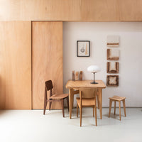 Light wood furniture with natural grain patterns against a minimalistic white background. Modern, warm tones throughout.
