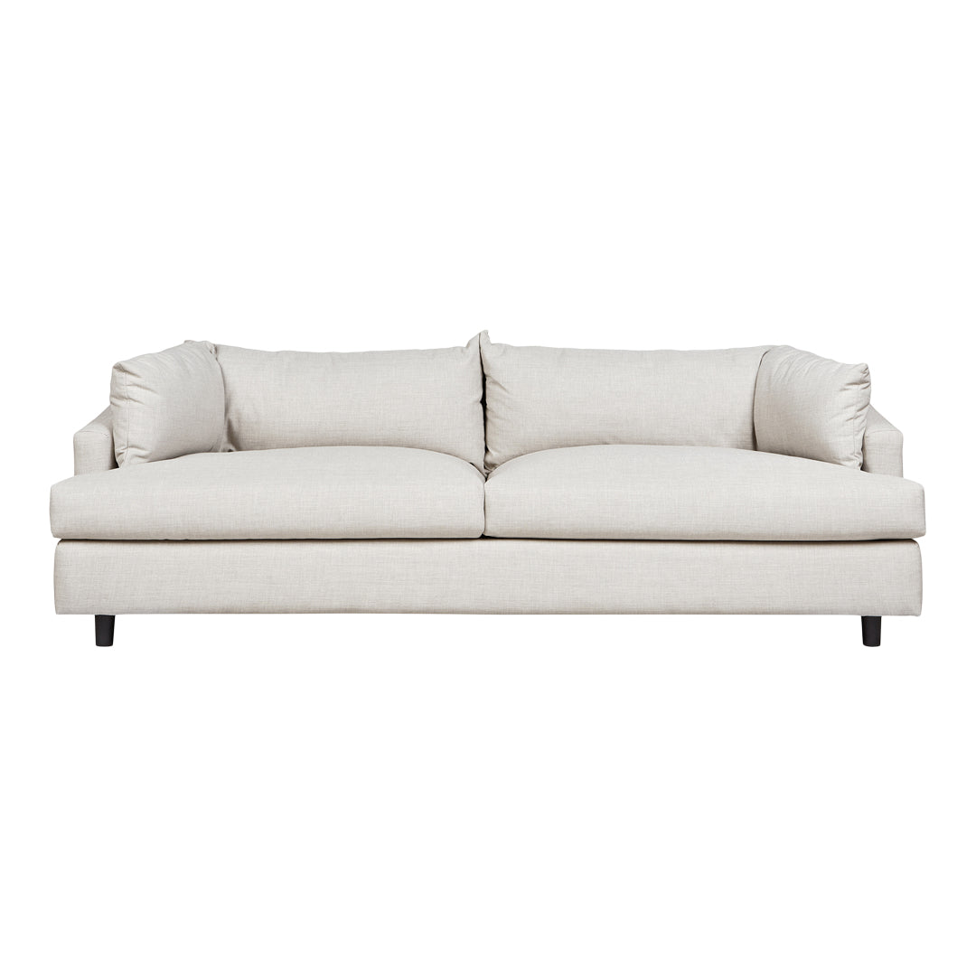 Cream-colored upholstered sofa with a smooth, minimalist design and plush, soft cushions. Perfect for modern interiors.