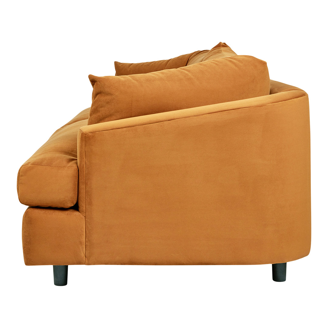 "Side view of a modern sofa in warm orange fabric with soft, textured cushions and sleek black legs."