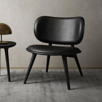Black mid-century modern chair with sleek contours and smooth leather finish on a neutral background.
