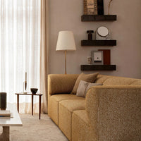 "Textured beige and mustard sofa with neutral throw pillows, soft beige curtains, and earthy tones in decor."