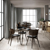 Modern dining set featuring a dark wood finish, sleek leather seats, and soft gray curtains in a light, airy room.