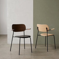 "Two modern chairs: one in dark wood and black, the other in light wood against neutral and green backgrounds."