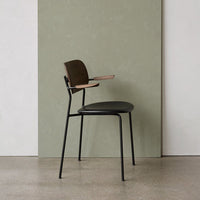Stylish black and brown chair with a minimalist design against a smooth green backdrop. Modern and sleek aesthetic.