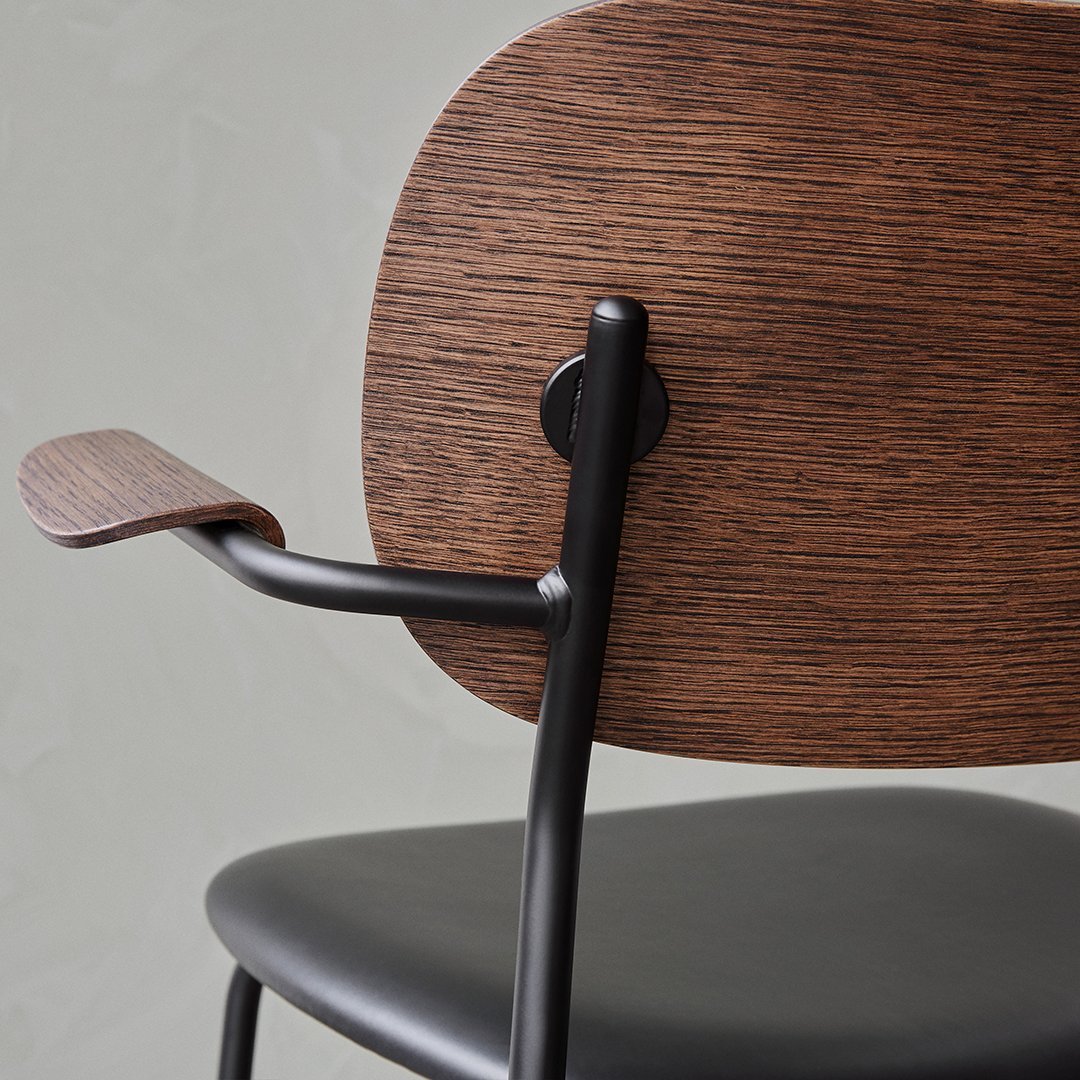 Stylish chair featuring a rich wood grain backrest and sleek black metal frame.