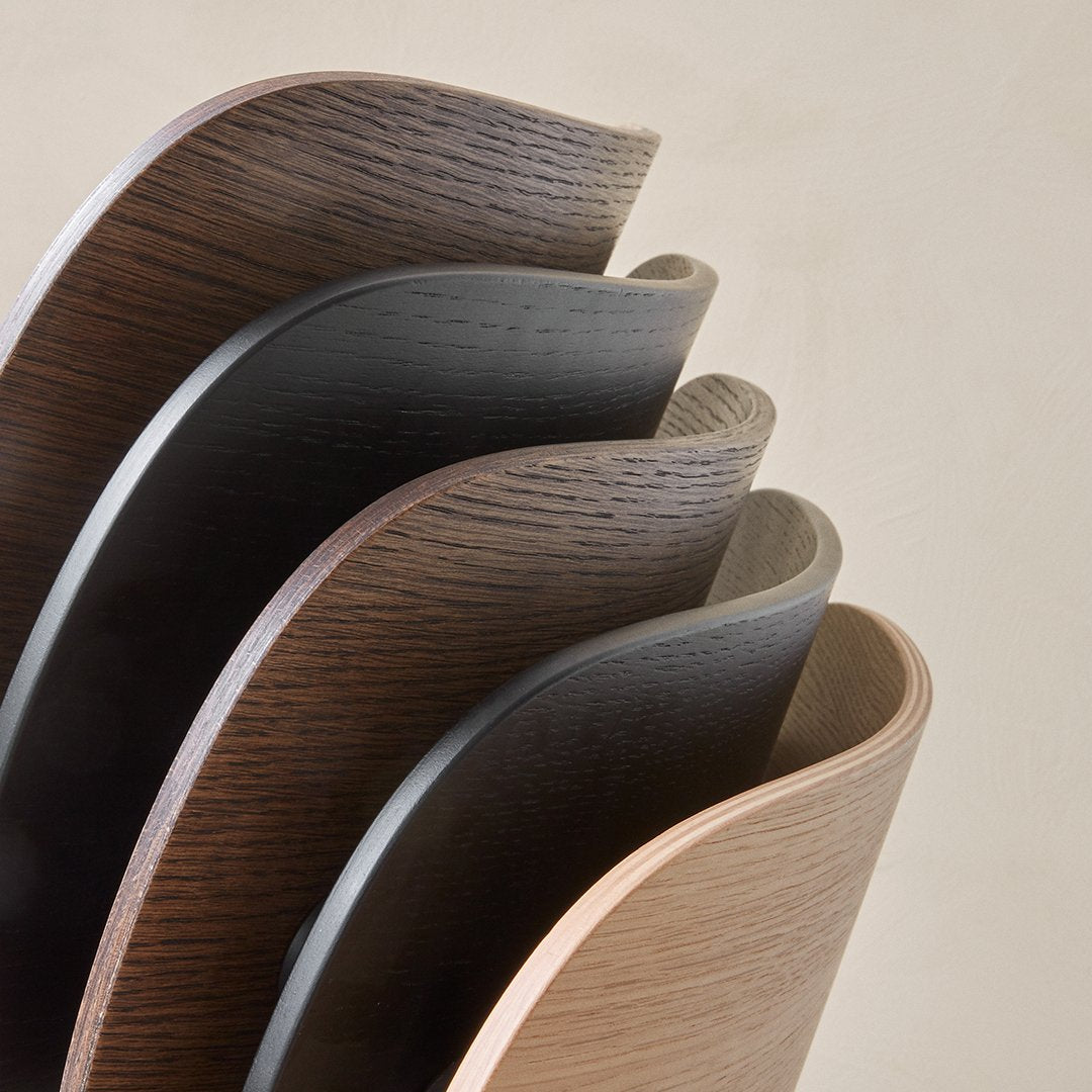 Curved wooden shelves in varying shades of brown and black, showcasing smooth, wavy patterns for modern decor.