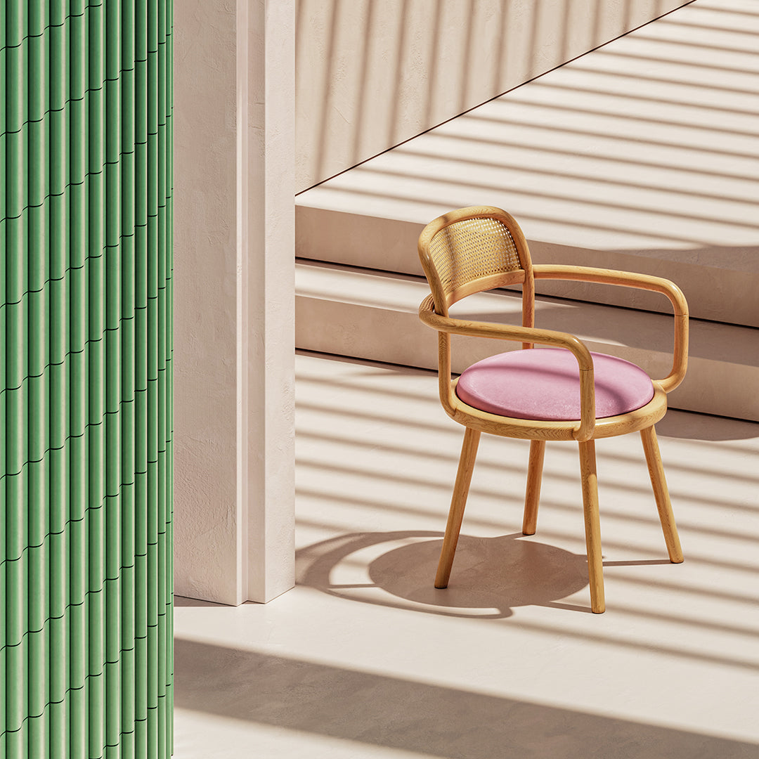 Modern chair with a pink cushion, natural wood frame, and vertical green bamboo backdrop, featuring soft shadows.