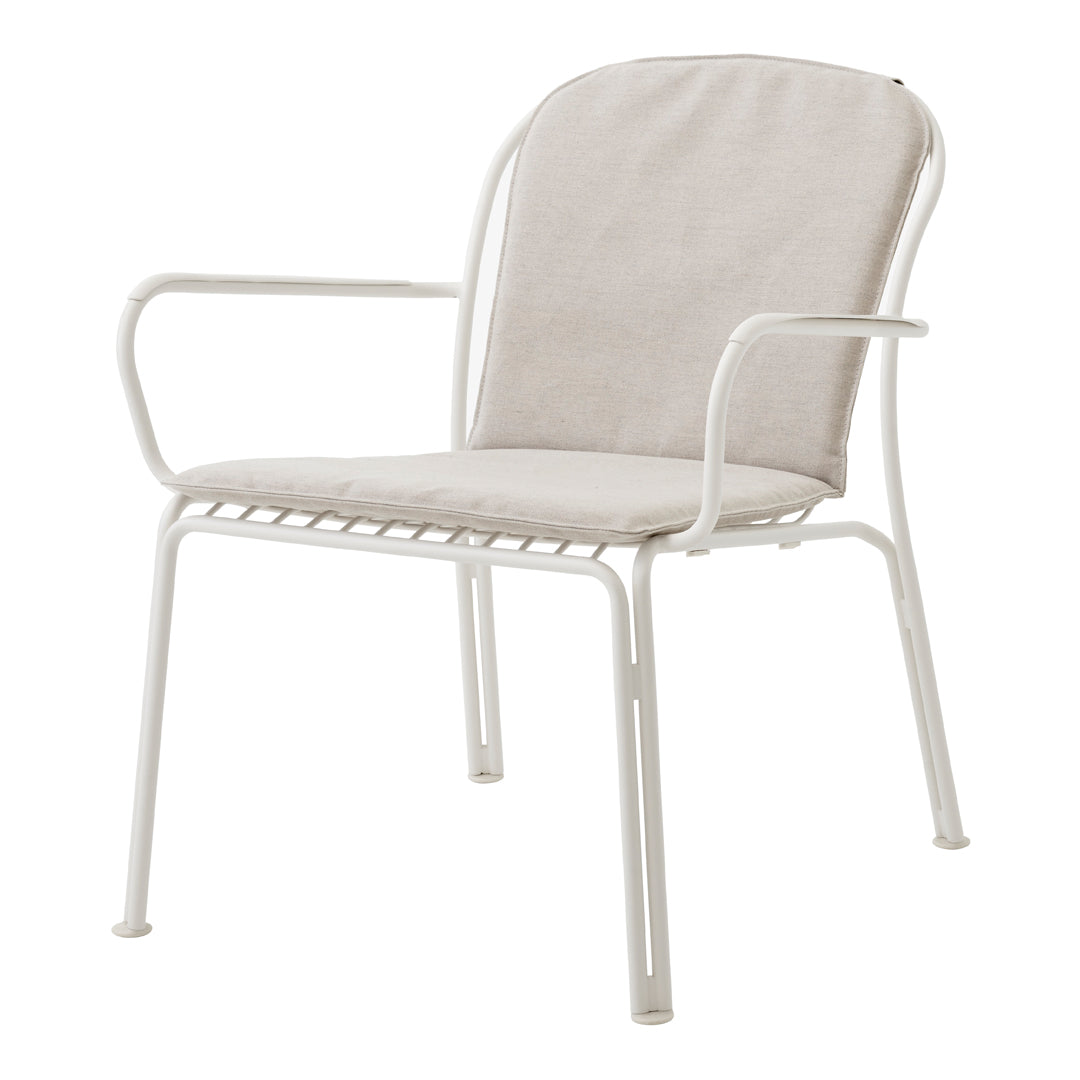 Light beige cushioned chair with a minimalist white metal frame, perfect for modern decor.