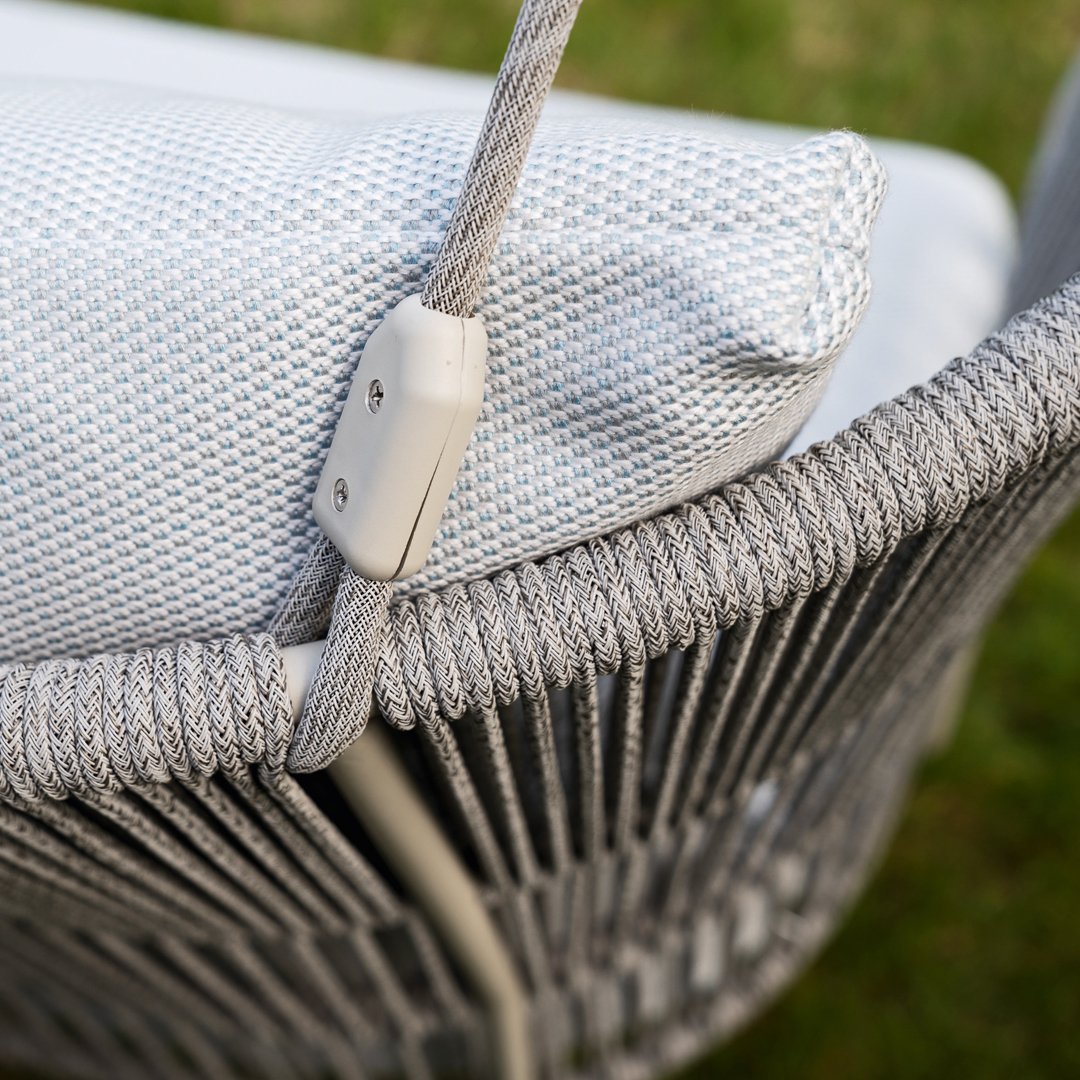 Light gray woven chair with a textured white cushion, featuring subtle geometric patterns for a modern touch.