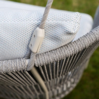 Light gray woven chair with a textured white cushion, featuring subtle geometric patterns for a modern touch.