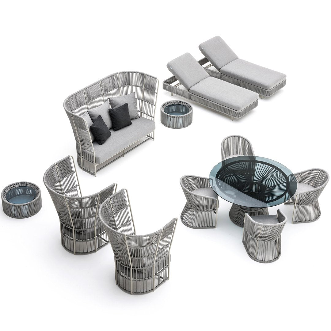 Gray wicker patio furniture set with sleek lines, complemented by dark gray cushions and round glass tabletop.