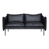 Black leather sofa with smooth texture and sleek lines, featuring plush cushions on a minimalist metal frame.