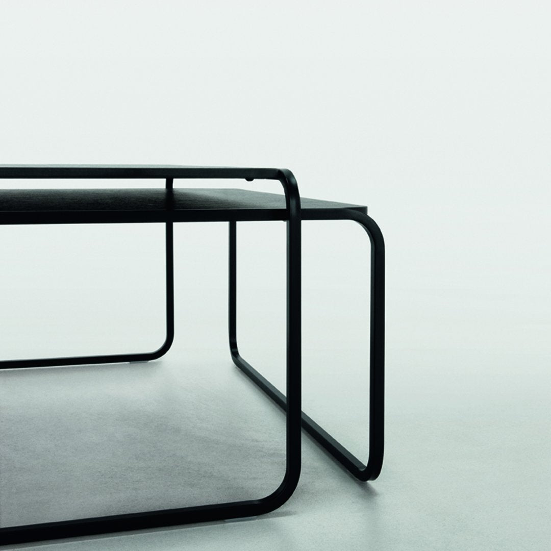 Minimalist black metal desk with sleek lines and a matte surface on a neutral background.