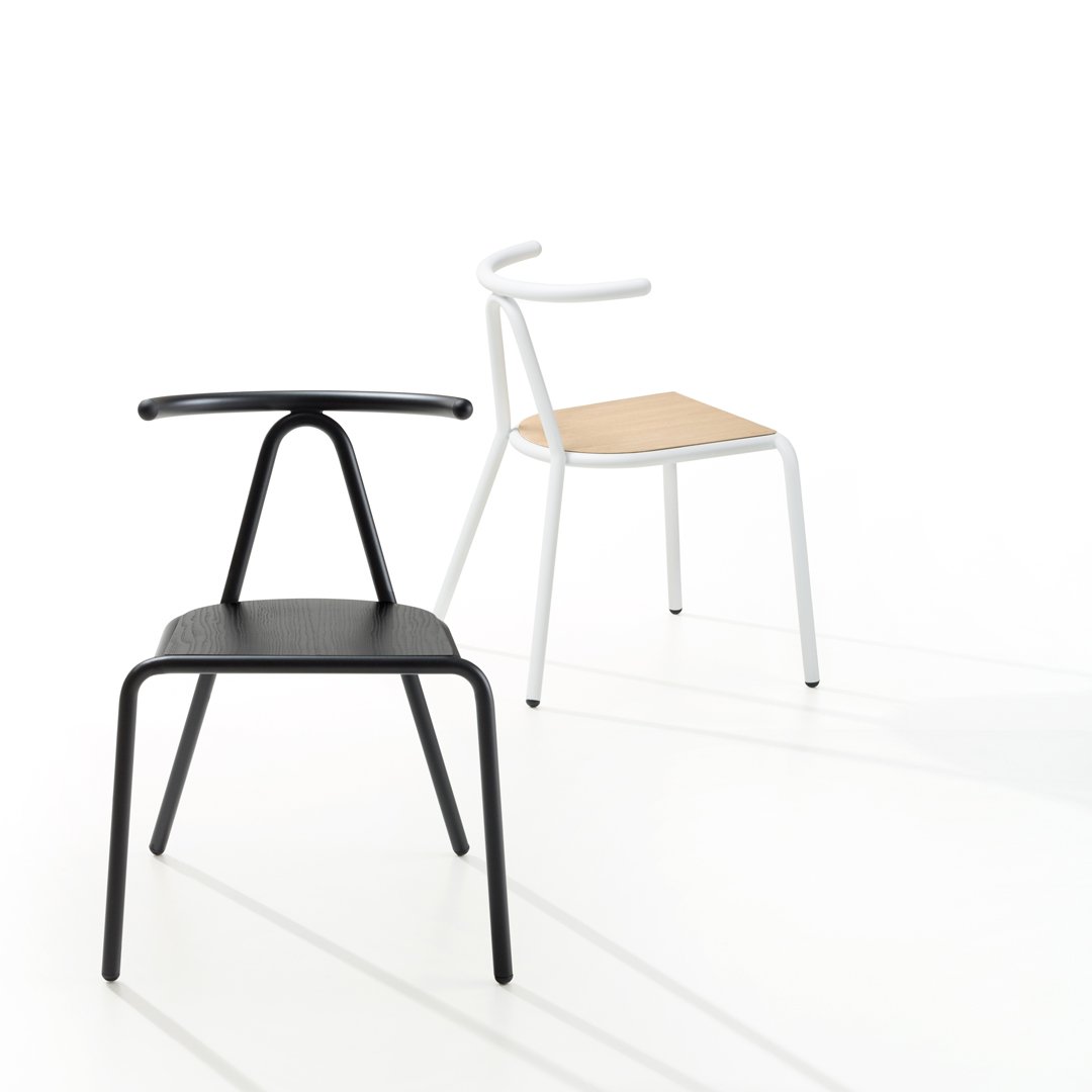 "Black and white chairs with wooden seat, showcasing modern design and minimalist style against a bright background."