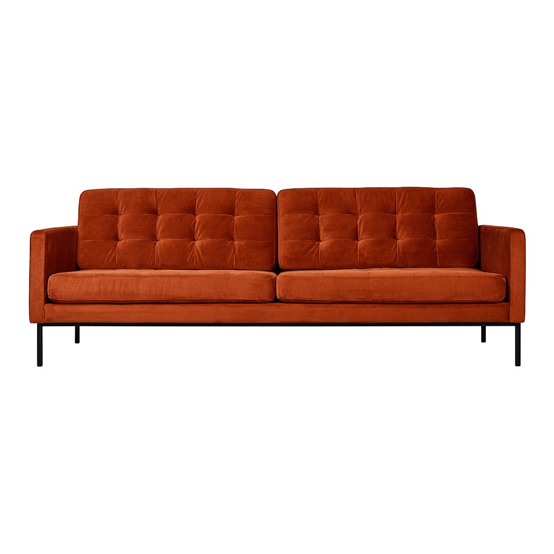 Rust orange tufted sofa with a sleek black metal frame, featuring a modern, minimalist design.