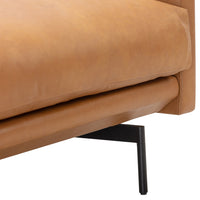 Tan leather sofa close-up with smooth texture and sleek black metal legs, showcasing a minimalist design.