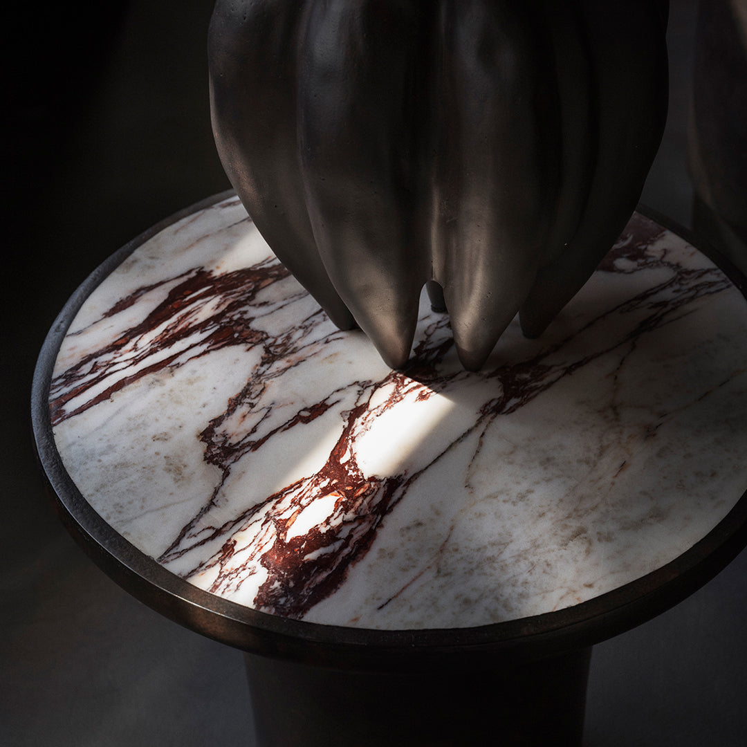 Marble table top featuring rich burgundy and white veining on a sleek black base, creating a striking contrast.