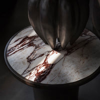 Marble table top featuring rich burgundy and white veining on a sleek black base, creating a striking contrast.