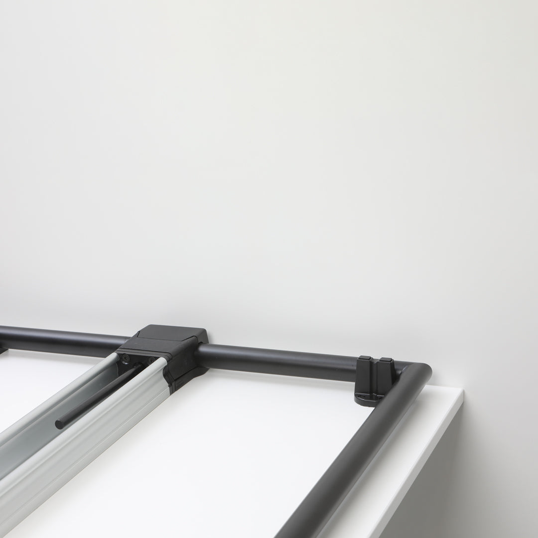 Black metal frame with silver accents on a sleek white background, minimalistic design with clean lines.