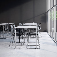 Modern black and silver chairs with a minimalist design, featuring clean lines and a sleek tabletop in a bright setting.