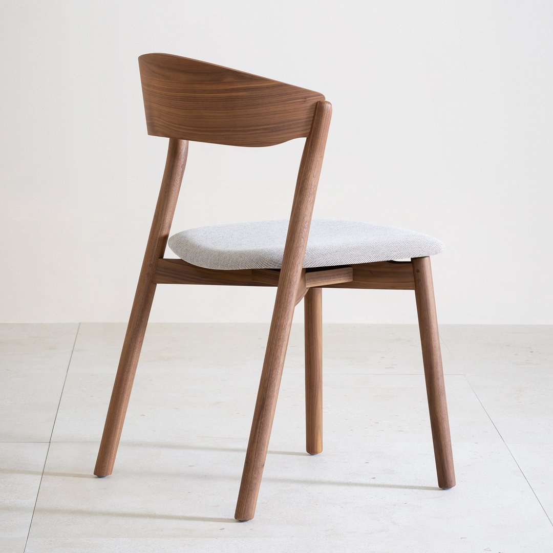 Warm walnut wood chair with a light gray upholstery seat and a minimalist design, enhancing modern interior aesthetics.