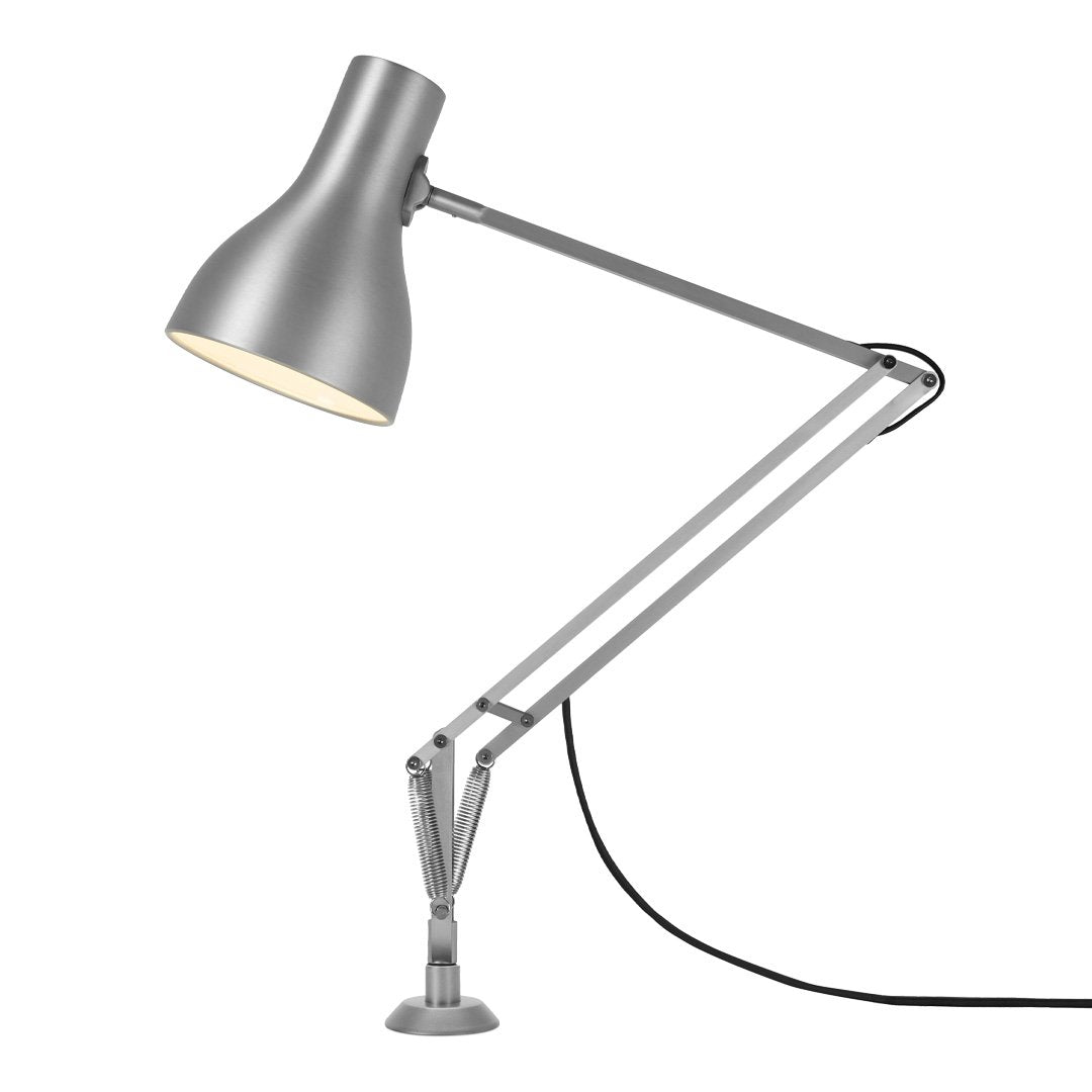 Silver metal desk lamp with a sleek, modern design and streamlined adjustable arm. Simple and stylish illumination.