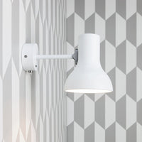White wall lamp against a gray geometric patterned wall featuring alternating diamonds.