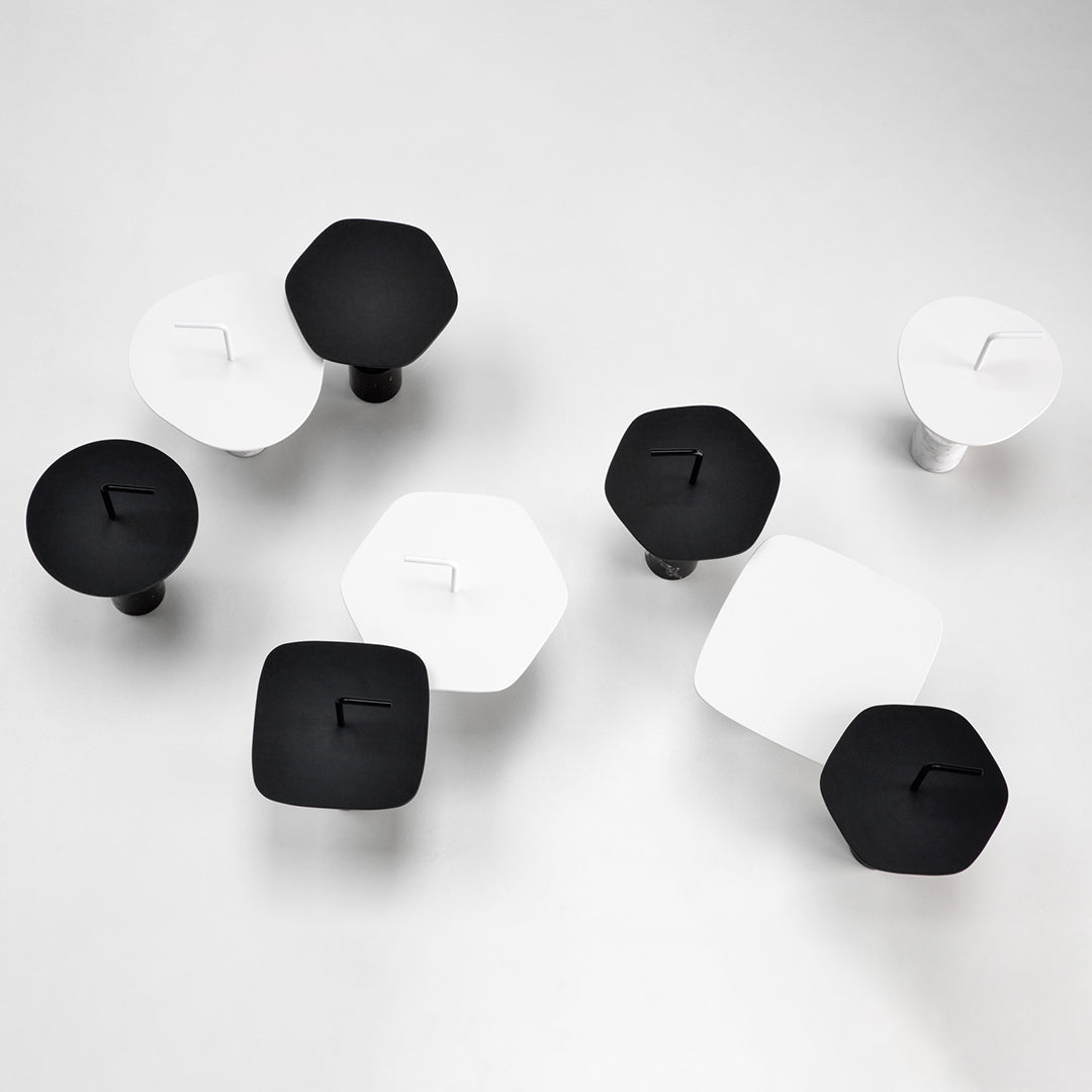 Black and white geometric knobs in hexagonal and square shapes arranged artistically on a light background.