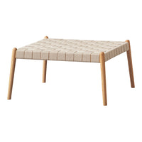 Beige woven tabletop with a textured grid pattern and natural wood legs. Modern minimalist design for versatile decor.