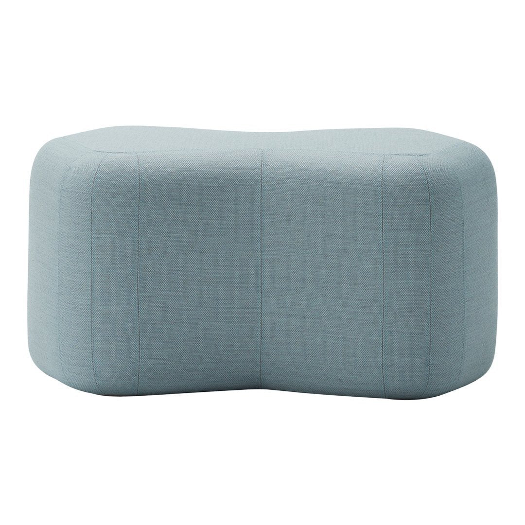 Soft blue upholstered ottoman with a textured, subtle pattern, featuring a modern, unique shape.