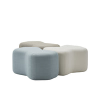 Three modern, soft ottomans in light blue, gray, and cream with smooth, textured finishes. Perfect for stylish decor.