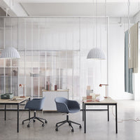 Modern office setup featuring soft blue chairs, minimalist decor, and neutral tones in a bright, airy space.