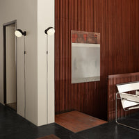 "Modern interior with dark wood paneling, black floor, white light fixtures, and minimalistic design elements."