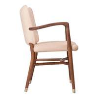 "Elegant blush pink upholstered chair with warm wood frame and gold accents, perfect for modern decor."
