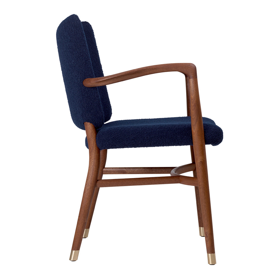 Navy upholstered chair with a wooden frame and brass accents, featuring a sleek, modern design.
