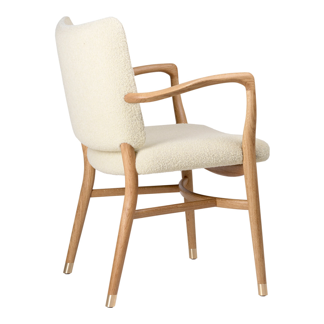 Cream-colored upholstered chair with natural wood accents and soft, textured pattern. Stylish and modern design.
