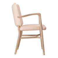 Blush pink upholstered chair with natural wood frame and gold accents, showcasing a smooth, minimalist design.