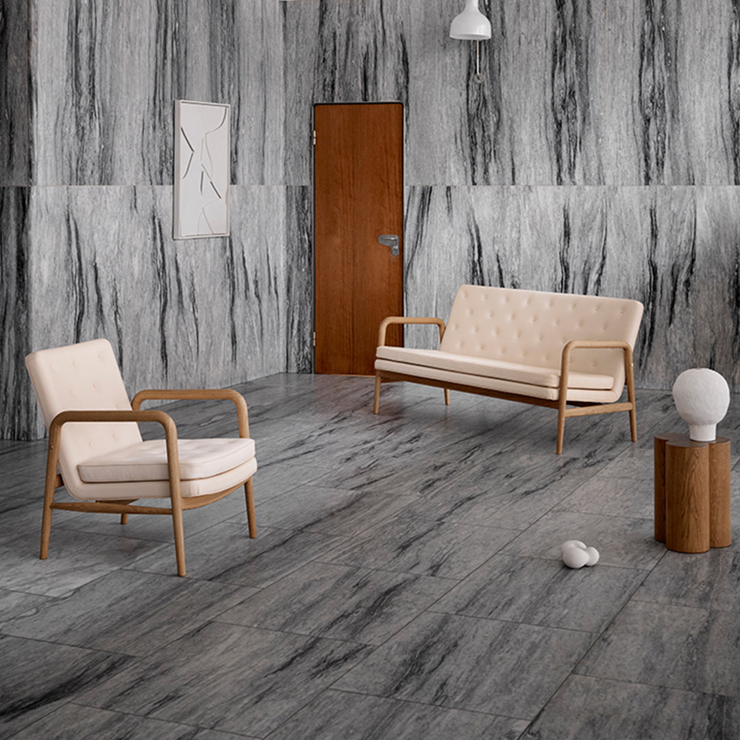 Modern living room featuring gray marble walls, light beige furniture, and a warm wood accent table. Elegant color contrast.