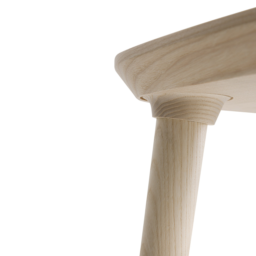 Light wood table leg with a smooth, natural finish and subtle grain patterns against a white background.
