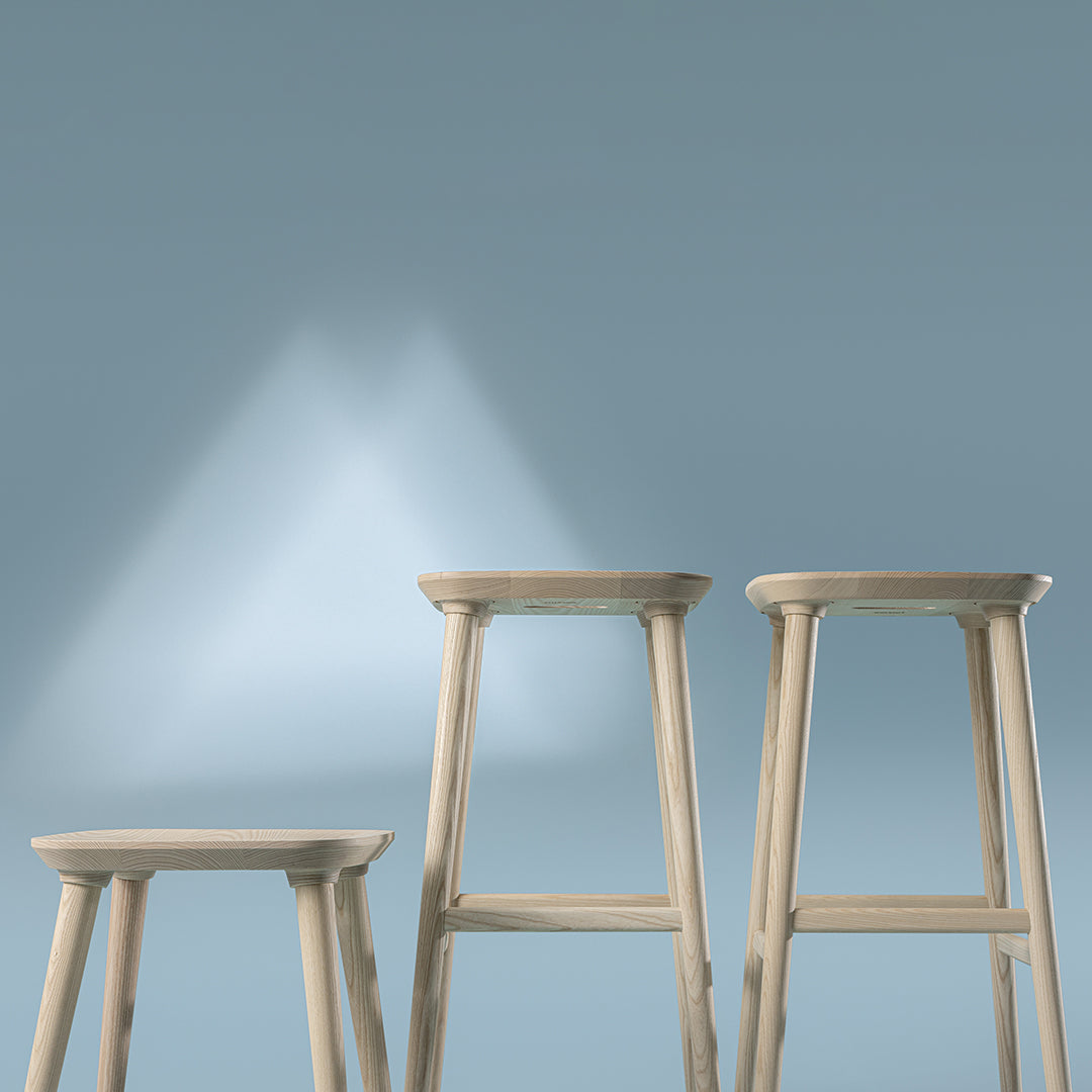 Light beige bar stools set against a soft blue background with subtle light patterns. Perfect for modern decor.